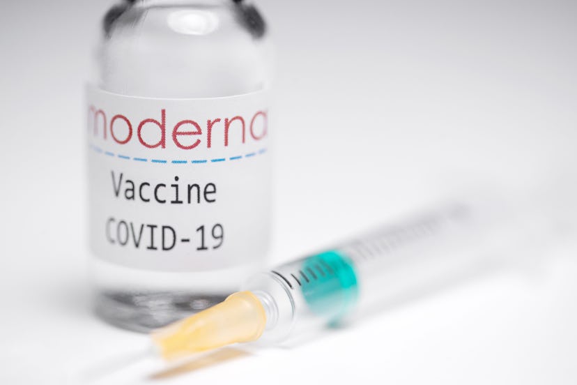 A vaccine needle and vial with a moderna logo on it.