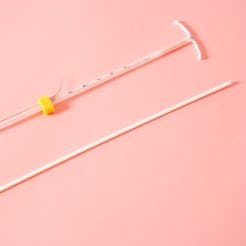 An IUD on a pink background.