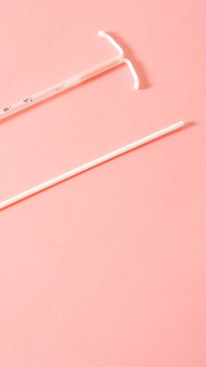 An IUD on a pink background.