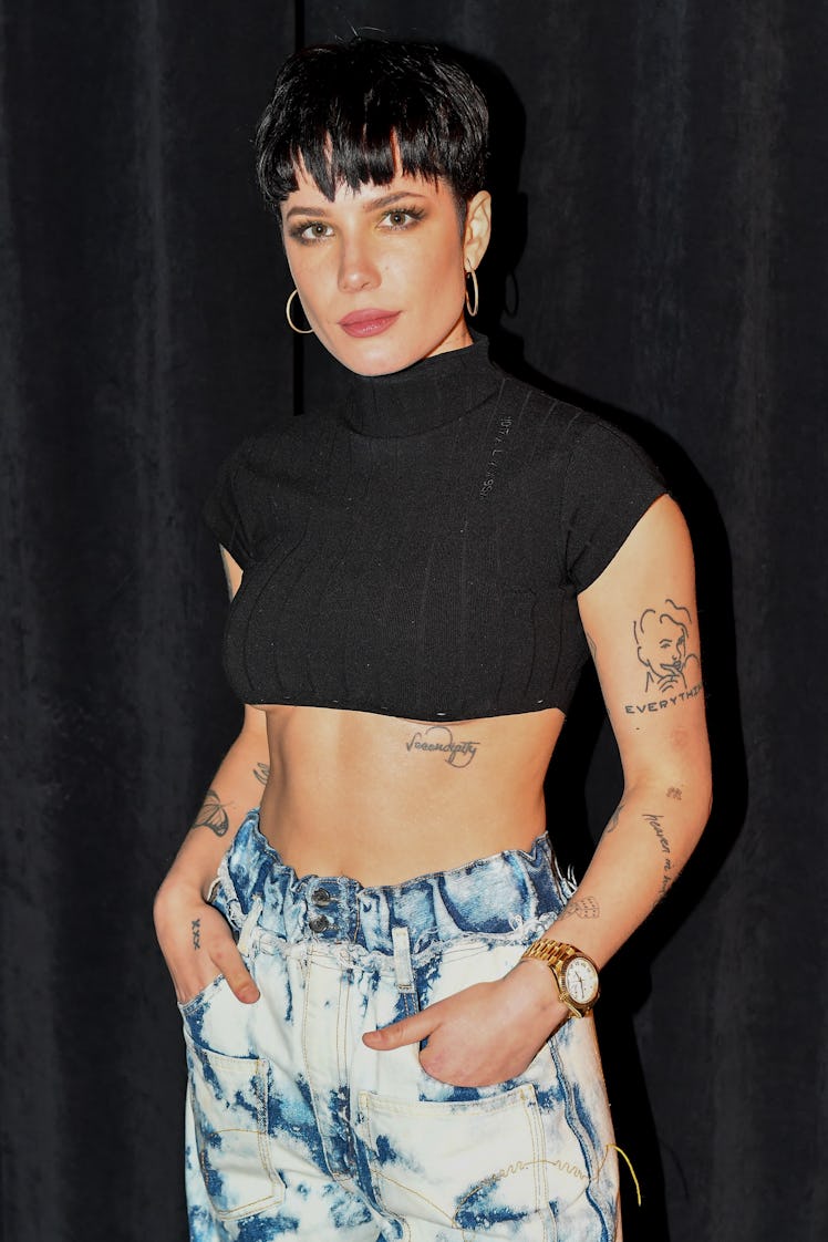 Halsey wears acid wash jeans and a black crop top.