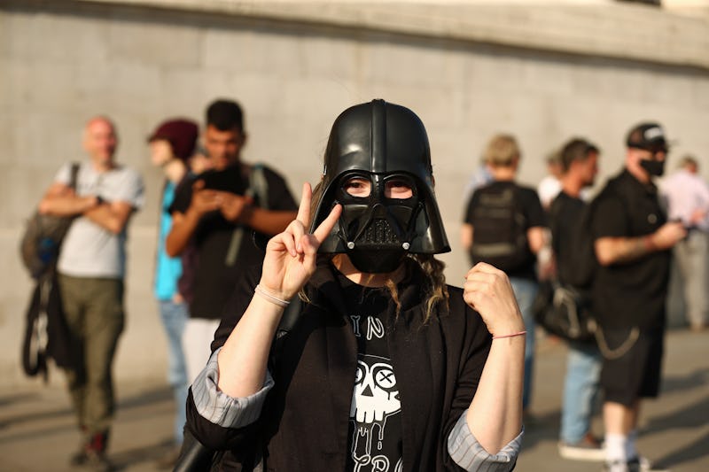 A demonstater in a Darth Vader mask star wars political protest 