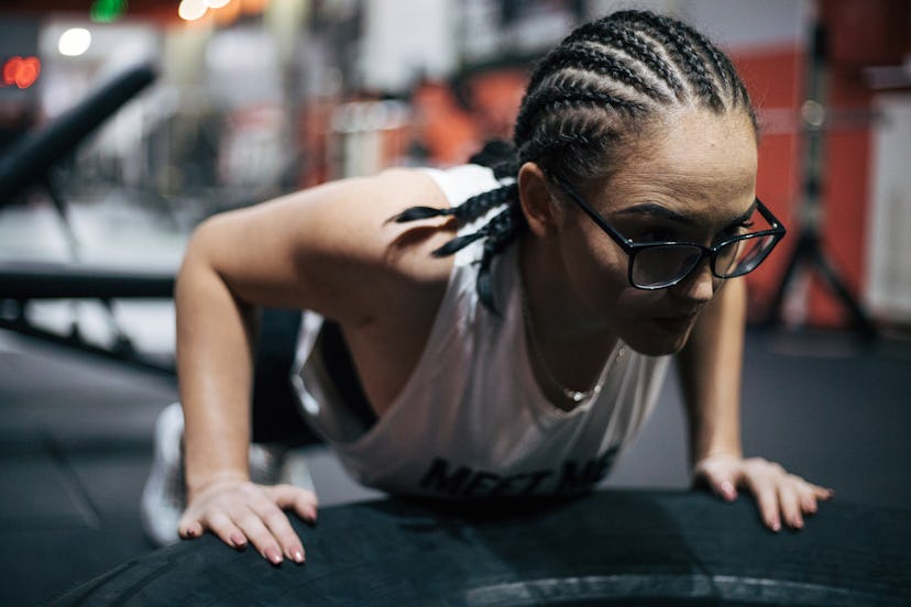 A person performs pushups on a tire at a gym. Slowing down your pushup with negatives can drasticall...