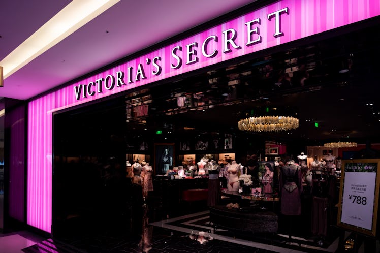 A Victoria's Secret store in the mall has pink lights at the entrance.