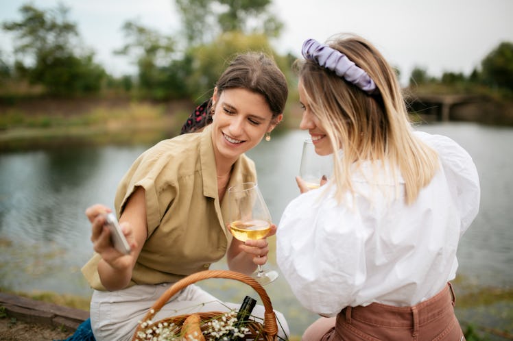 Two sisters take an outdoor picnic selfie.