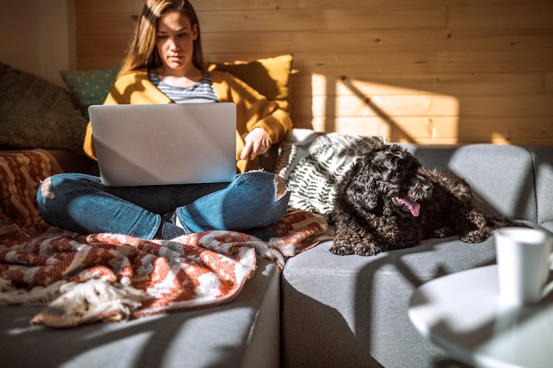 A woman in a cozy sweater browses virtual holiday gifts you can give during the COVID-19 pandemic.