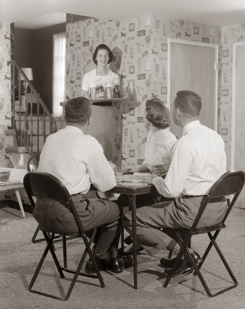 A vintage photo of two couples playing a board game. Experts believe that an isolation bubble to lim...