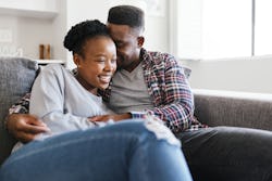 A couple cuddling on the couch during Thanksgiving