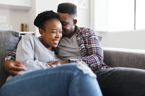 A couple cuddling on the couch during Thanksgiving