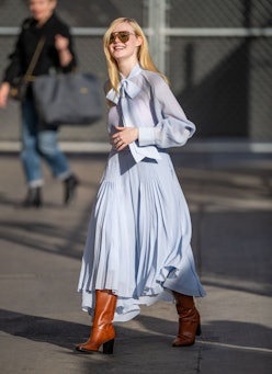 Blonde lady walking in a light blue dress 