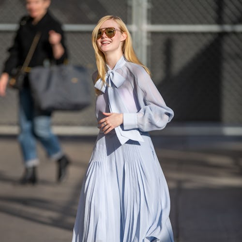 Blonde lady walking in a light blue dress 