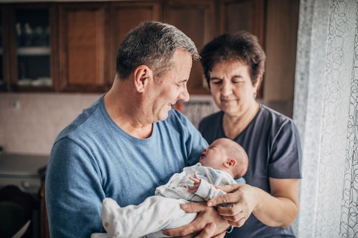 Grandparents holding newborn baby.