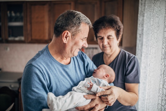 Grandparents holding newborn baby.