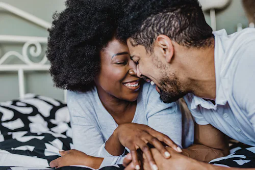 A couple cuddling on a bed during the Thanksgiving break.