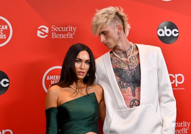 Megan Fox in a green dress and Machine Gun Kelly in a white suit on the AMAs red carpet event