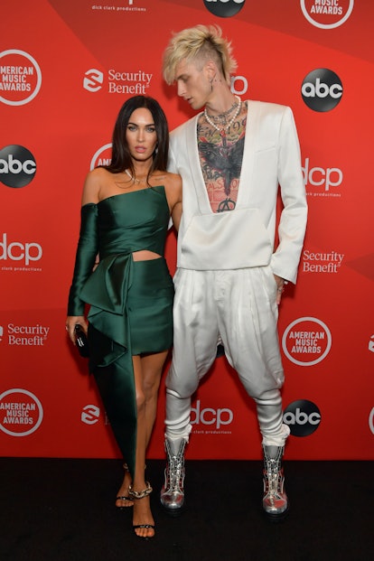 Megan Fox in a green dress and Machine Gun Kelly in a white suit on the AMAs red carpet event