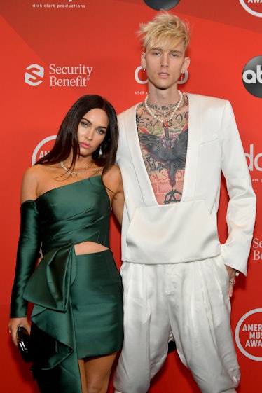 Megan Fox in a green dress and Machine Gun Kelly in a white suit on the AMAs red carpet event and sh...