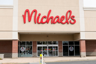 A Michaels store front has "buy online" signs on the windows on a sunny day. 