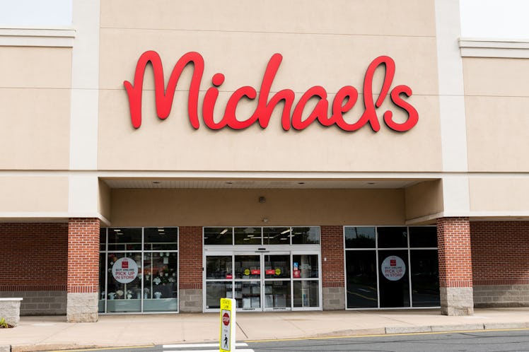 A Michaels store front has "buy online" signs on the windows on a sunny day.
