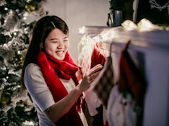 A woman admires some holiday stockings hung on the chimney at Christmas. 