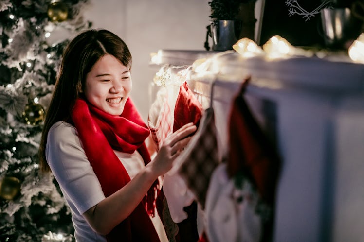 A woman admires some holiday stockings hung on the chimney at Christmas.