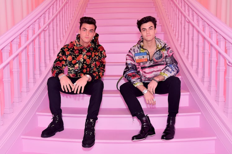 The Dolan Twins from YouTube sit on a pink staircase.