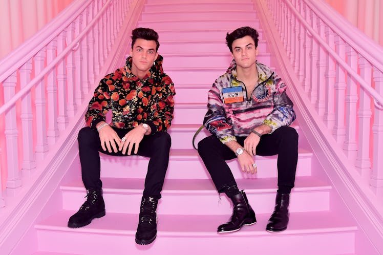 The Dolan Twins from YouTube sit on a pink staircase. 