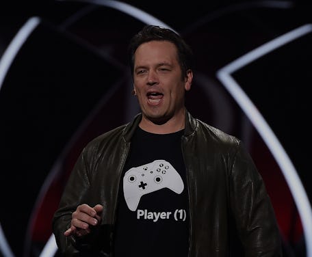 The head of Xbox, Phil Spencer, can be seen mid-speech at an Xbox conference. Spencer is wearing a s...