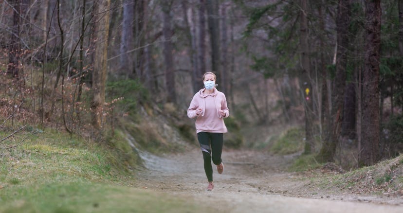 A person wears a hoodie and a mask while running through on a trail. Turning off your music can boos...