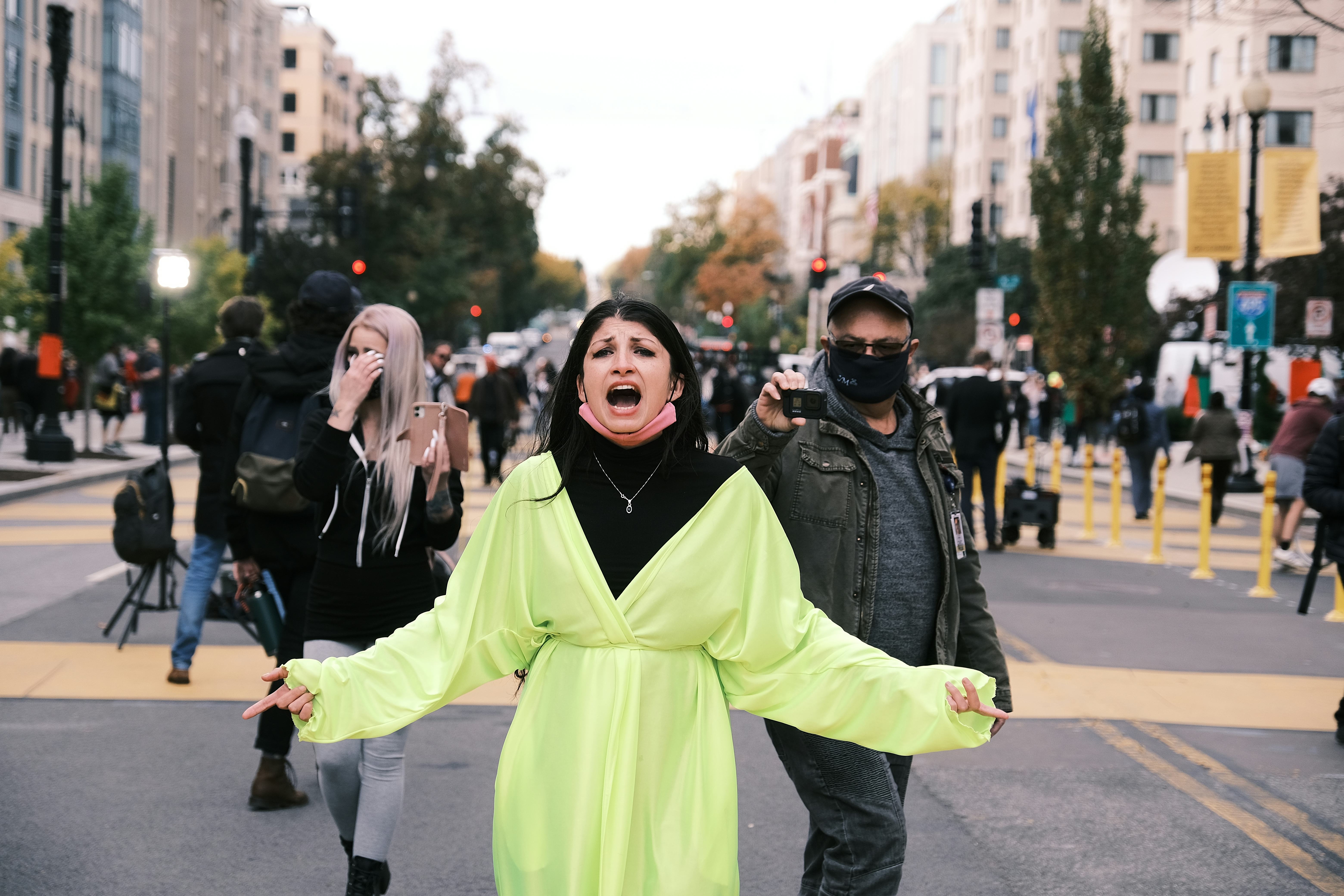 A woman in a green coat on the street during the Election Day 2020 