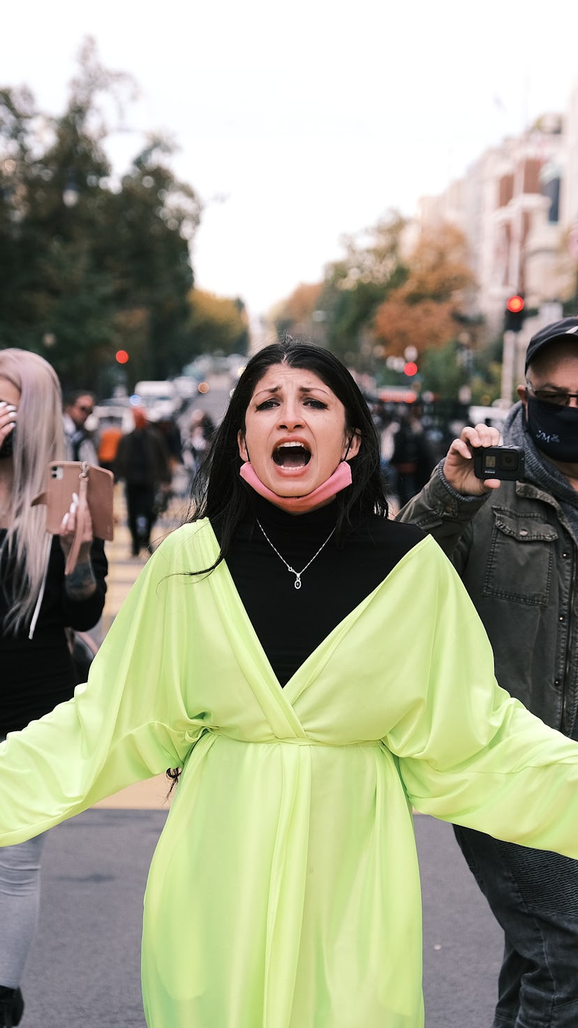 A woman in a green coat on the street during the Election Day 2020 