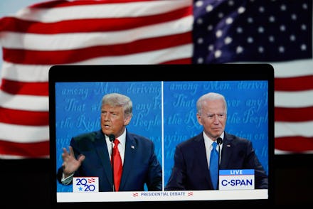 Donald Trump and Joe Biden debate livestream on a laptop with the American flag in the background