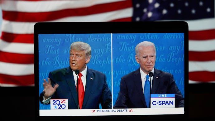 Donald Trump and Joe Biden debate livestream on a laptop with the American flag in the background