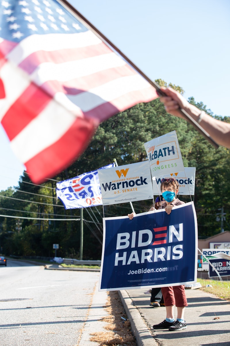 An american flag waves in the background of a Biden/Harris lawn sign. Abortion rights advocates say this issue could turn Georgia blue.