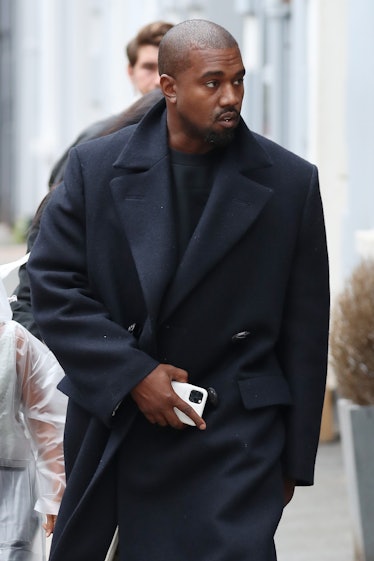 Kanye West steps out in a black trench coat.