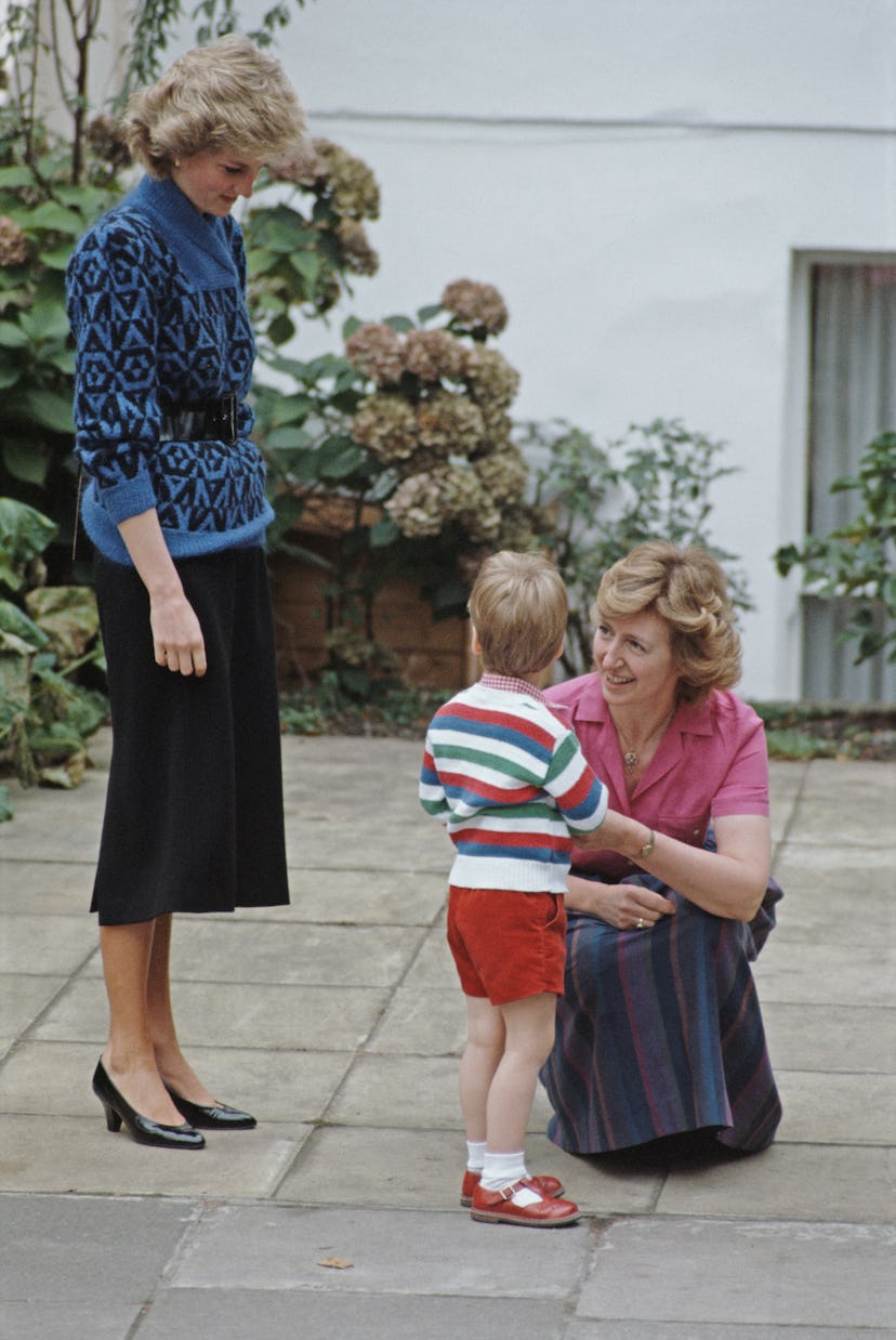 Princess Diana wears a blue sweater with a belt.