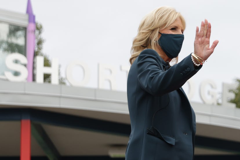 Jill Biden wearing a black blazer and waving with her right hand