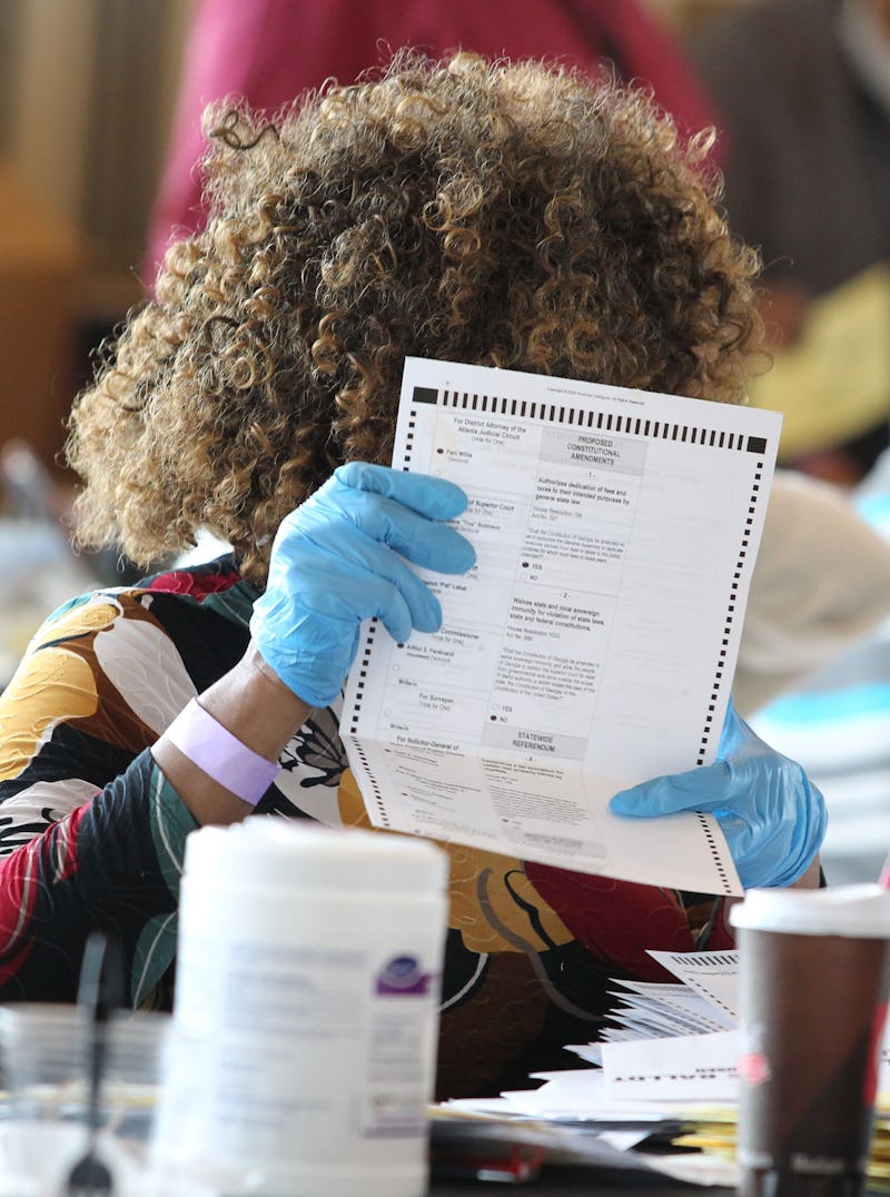 Fulton County election workers examine ballots while vote counting, at State Farm Arena on November ...