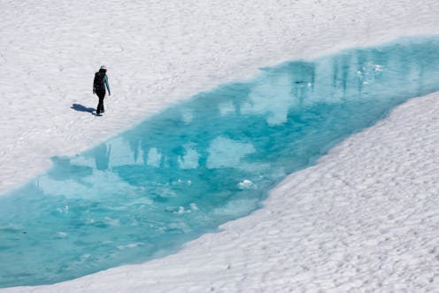 A person stands next to a frozen river. Winter mental health tips allow you to get creative.