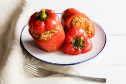 Stuffed red bell peppers on a white plate as a turkey alternative for thanksgiving
