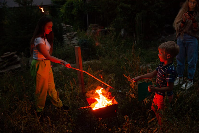kids roasting marshmallows at a bonfire