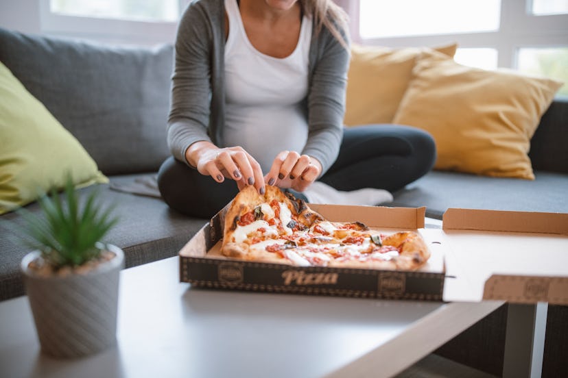 pregnant woman eating Jalapeno poppers pizza