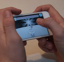 Person playing a game on an iPhone.