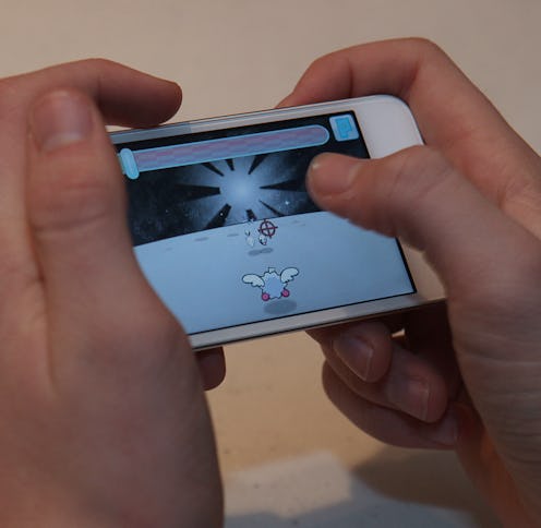 Person playing a game on an iPhone.