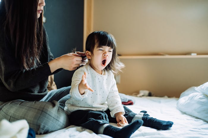 Tired toddler girl yawning due to sleep regression