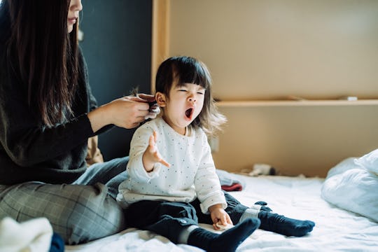 Tired toddler girl yawning due to sleep regression