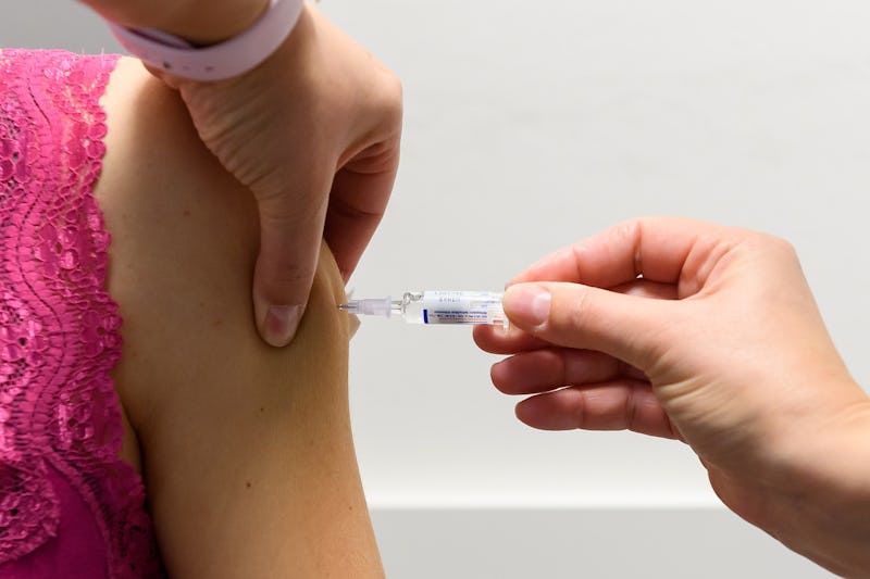 A person in a pink shirt receives the COVID-19 vaccine. Should people with allergies get the vaccine...