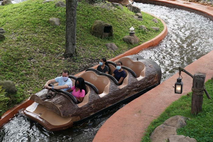 A small group of masked guests take a ride on Splash Mountain at Walt Disney World Resort.