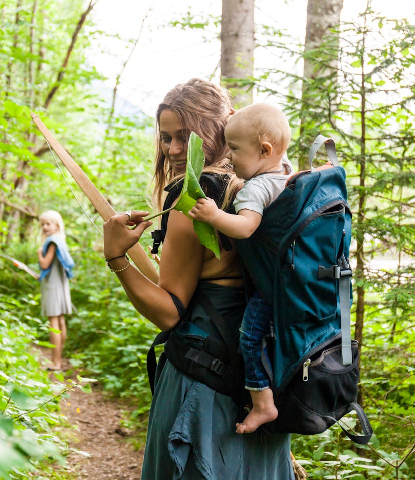 mom on hike in woods with baby on back