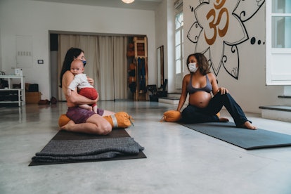 a pregnant woman and new mom at a baby yoga class
