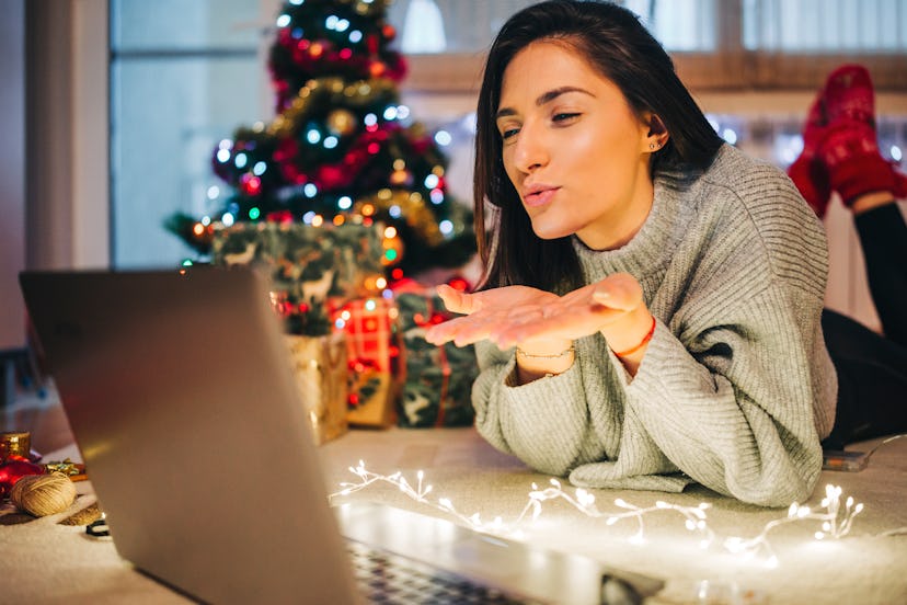 A woman in a long-distance relationship sending a kiss over a call on new year's eve